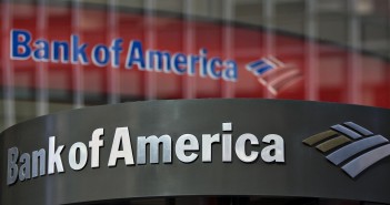 A Bank of America logo hangs above a bank branch entrance in