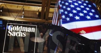 The Goldman Sachs logo is displayed on a post above the floor of the New York Stock Exchange